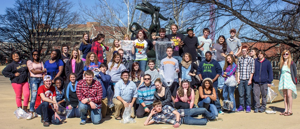 PCUB students pose next to statue